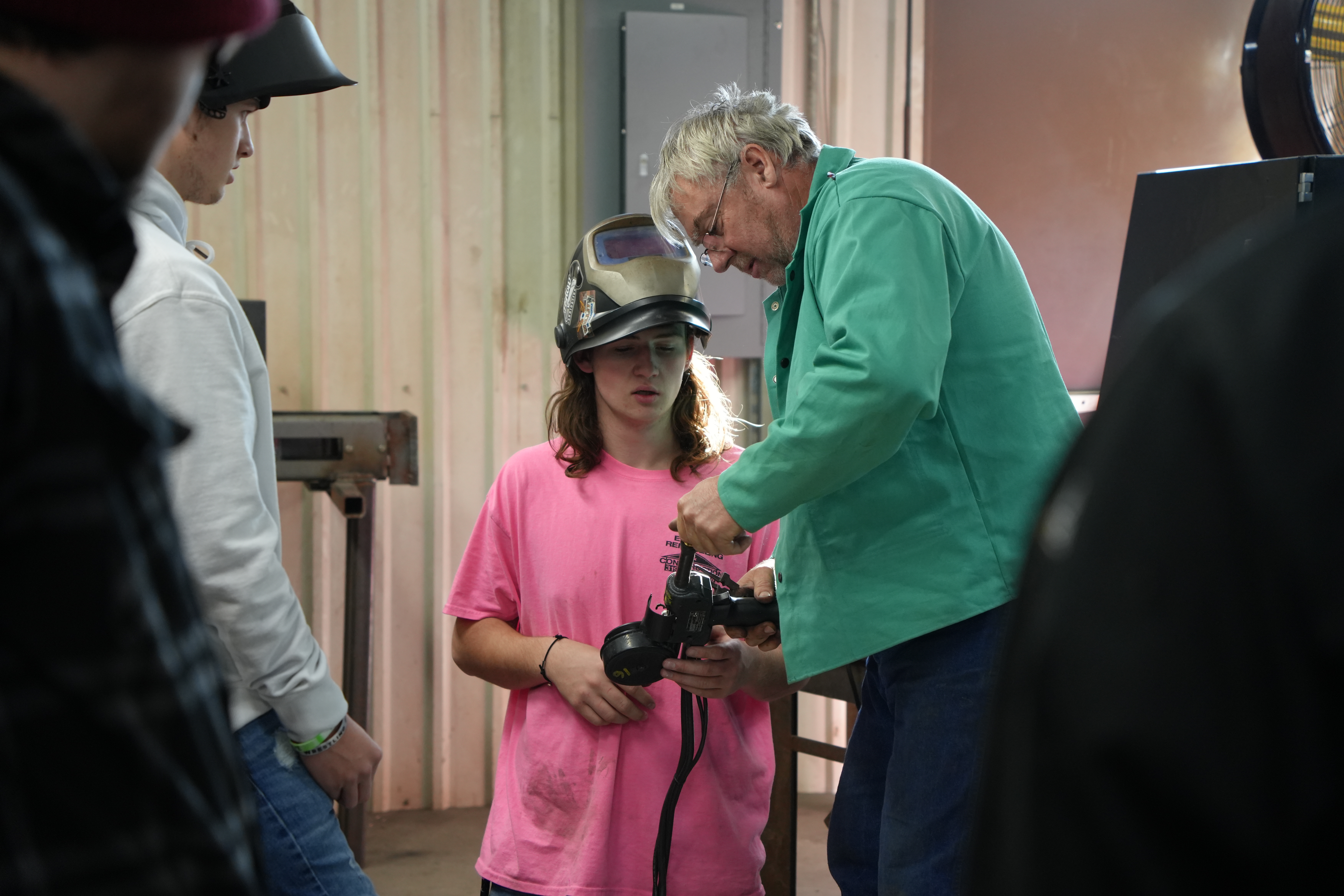 Welding instructor Mike Begyn helping young student